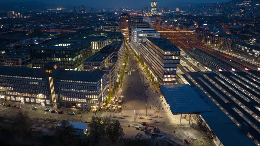 night illuminated zurich city train station district modern office block aerial panorama 4k timelapse switzerland