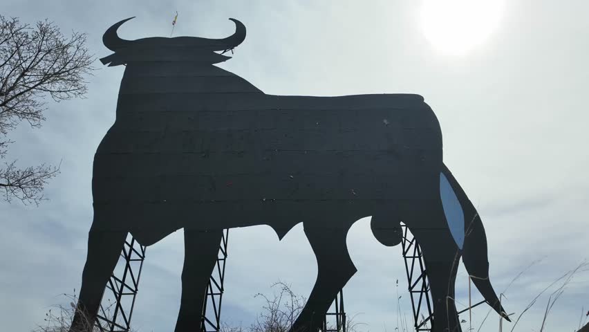 Extreme closeup view of a Spanish black bull abandoned billboard. Timelapse. Sunny, blue sky with some high clouds. 4K Royalty-Free Stock Footage #3482728113