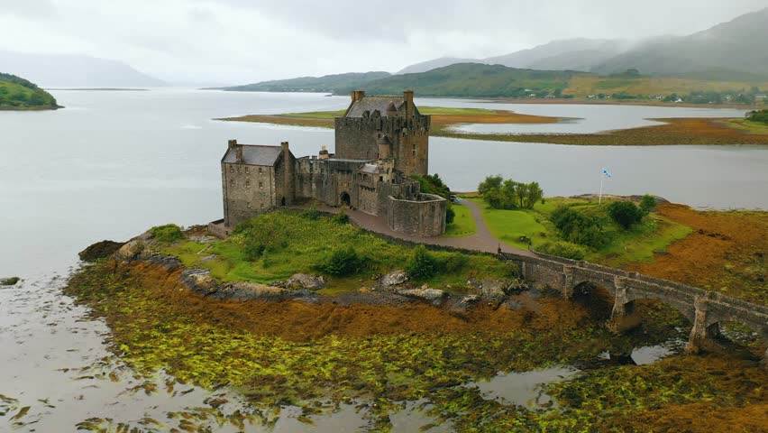 Eilean Donan Castle in Scotland at cloudy sunrise on low tide, UK - Historic Castle near Isle of Skye
