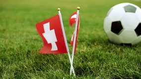 Flag of Switzerland and football ball on the grass. Swiss flag and soccer ball. - Powered by Shutterstock - Get 15% off with code: PIKWIZARD15