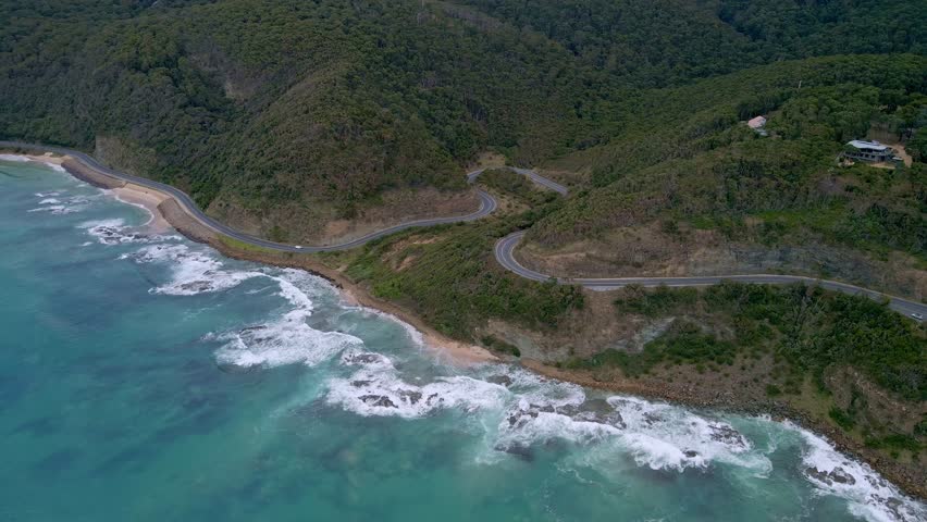 Drone shot of coastal winding highway bends along famous Great Ocean Road in Victoria, Australia