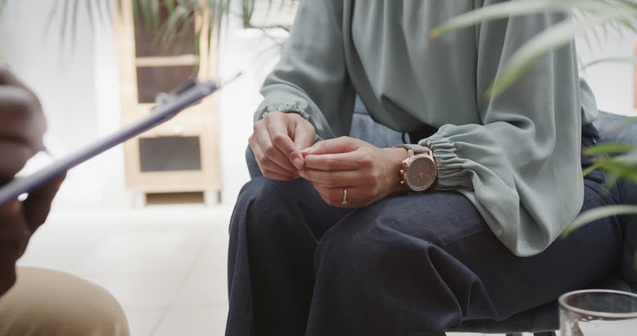 Midsection of diverse male therapist and female patient talking in therapy session, slow motion. Mental health, therapy and counselling.