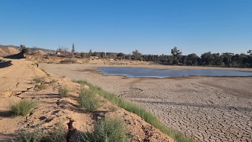 Endless cracked earth stretching into the horizon, a silent witness to the arid landscape, Algeria