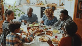 African American family members sitting at dinner table, having meal and talking during home celebration. High angle view - Powered by Shutterstock - Get 15% off with code: PIKWIZARD15