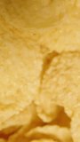Vertical video. Background of golden corn flakes for a nutritious breakfast. Top view. Dolly slider, close up.