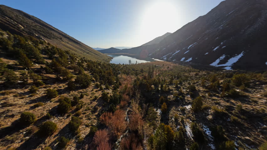 Flying on FPV Drone over Convict lake in the Eastern Sierra mountains covered with snow, California. High quality 4k footage Royalty-Free Stock Footage #3483050649