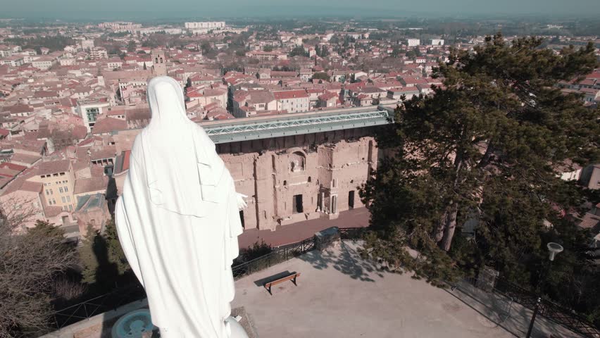 In the foreground the statue of the Virgin Mary who watches over the city of Orange and its ancient theater