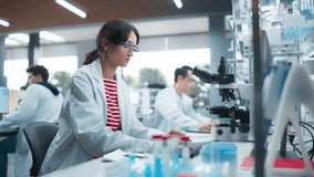 Team of Diverse Male and Female Medical Research Scientists Work on a New Generation Medical Products in a Modern Laboratory. Focus on a Young Woman Working on a Computer, Browsing Research Data - Powered by Shutterstock - Get 15% off with code: PIKWIZARD15
