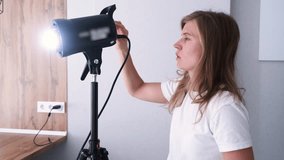 young woman working on content making using and controlling video light strobe