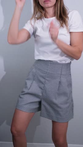 Enjoying freedom. woman in casual wear jumping and dancing in living room, carefree time having fun alone at home