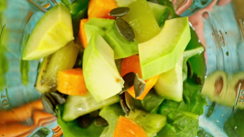 Super slow motion of mixing pieces of fruit and vegetables in blender, camera movement, top shot. Filmed on high speed cinema camera, 1000 fps.