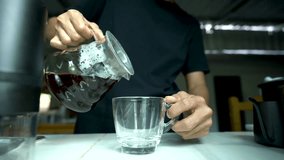 hand people pouring coffee into the transparent cup on the bar at kitchen home. 4k video