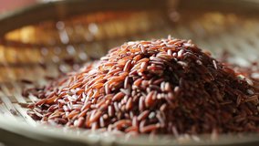 Pouring brown rice into basket closeup blurry background