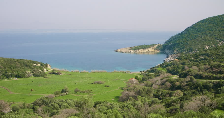 Beautiful Coastal Landscape with Tranquil Blue Sea, Serene Cove Nestled in Verdant Valley. View of the coastline and towns from hills adorned with green fields and small trees. (ProRes422, 10Bit)