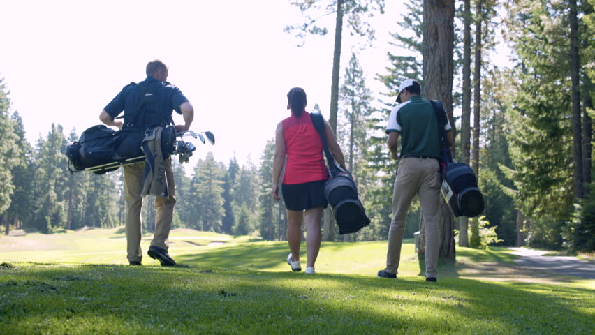 Three people walking on a golf course with sporting equipment Royalty-Free Stock Footage #34835542