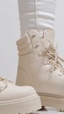 vertical video Closeup view spraying water on white color winter shoe protected with waterproof spray 