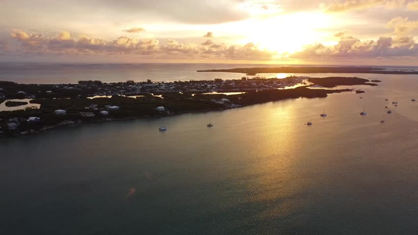 Summer Vacation in Spanish Wells, Bahamas. Flying my drone over the island during the sunset. There are many ships anchored in the water. The clouds made for a perfect backdrop of the setting sun.