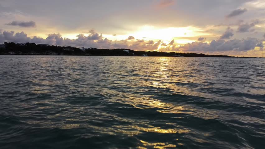 Summer vacation in The Bahamas. Flying my drone over the ocean as the sun is setting on the Island of Spanish Wells with sailboats anchored in the water. 