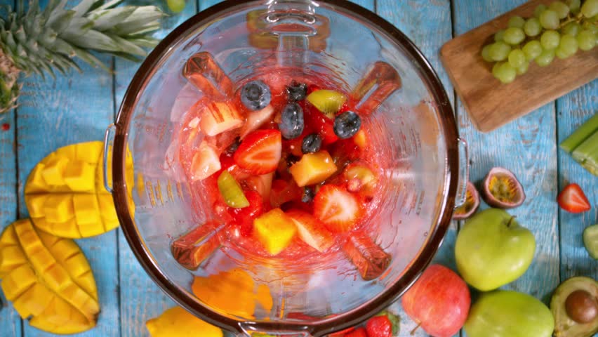 Super Slow Motion of Mixing Fruit Pieces into Blender. Camera Moving Up. Filmed on High Speed Cinema Camera, 1000 fps. Speed Ramp Effect.