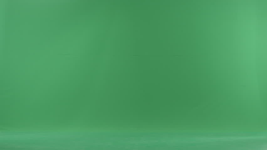 Happy young woman in Santa hat walks among snow and spinning around catching snowfalkes, chroma key background