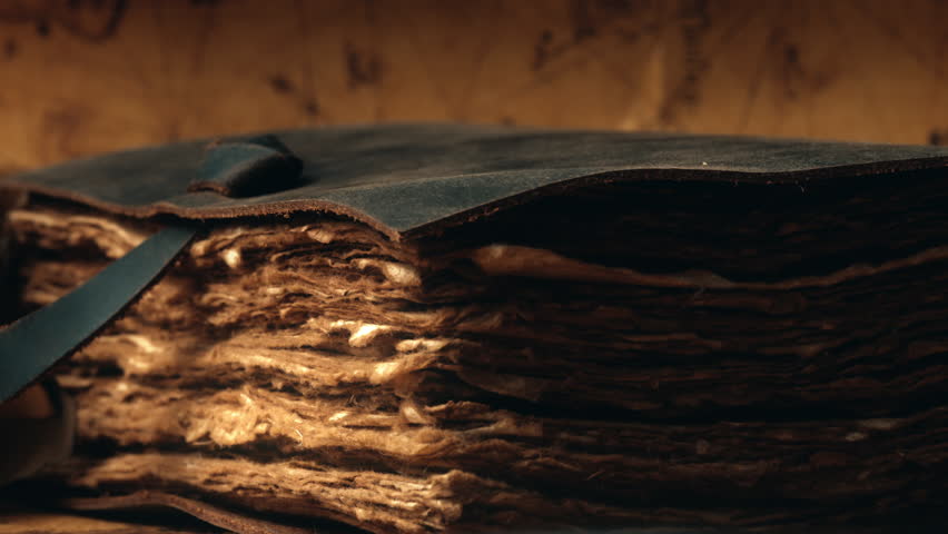 Antique old book resting on a wooden table. Vintage antiquarian literary relic featuring an ancient scroll