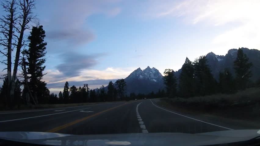 Driving southbound on Jenny Lake road in view of the Teton mountains in Grand Teton National Park Wyoming
