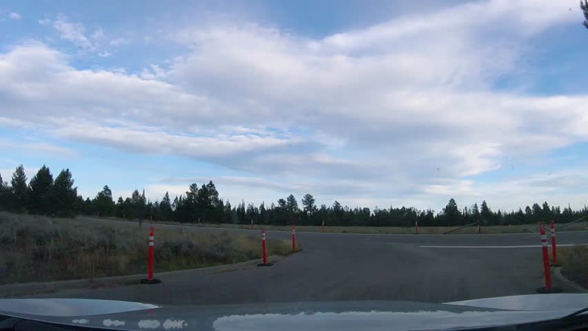 Driving southbound on Jenny Lake road in view of the Cathedral Group mountains in Grand Teton National Park Wyoming