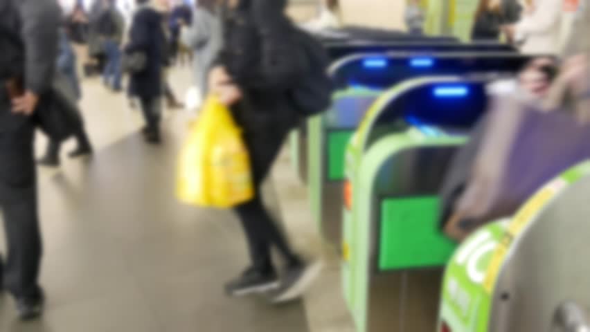Blurred out of focusing view of the ticket gate in the train station with many passenger get through the ticket gate in rush hour with RFID card in metropolitant big city of Tokyo