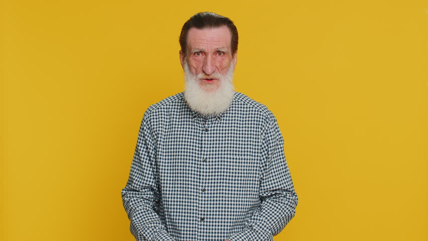 Oh my God, Wow. Excited amazed winner senior man raising hands in surprise looking at camera with big eyes, shocked by sudden victory celebrating success achievement good news. Grandfather on yellow