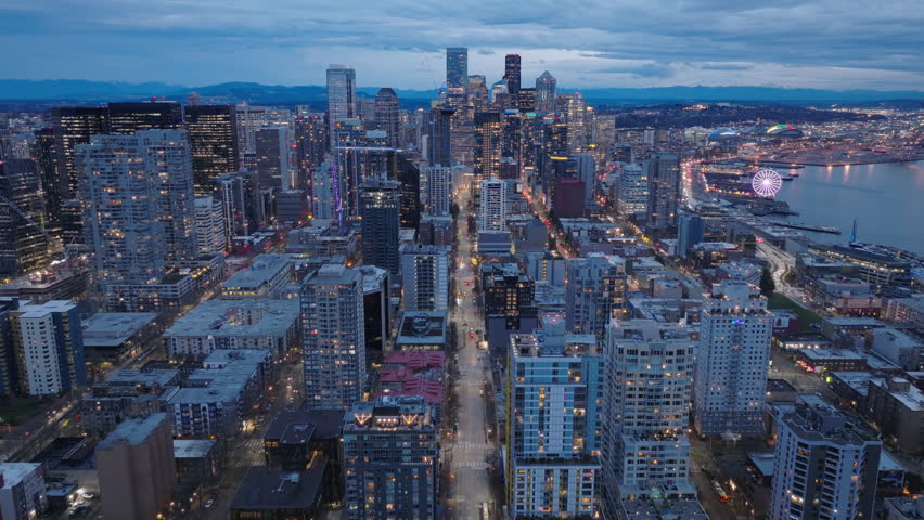 Cityscape at sunset scene. Seattle financial business district at night. Business background at colorful sunset sky. Downtown dusk skyline Washington. Aerial view of sunset skyline Seattle city USA 4K