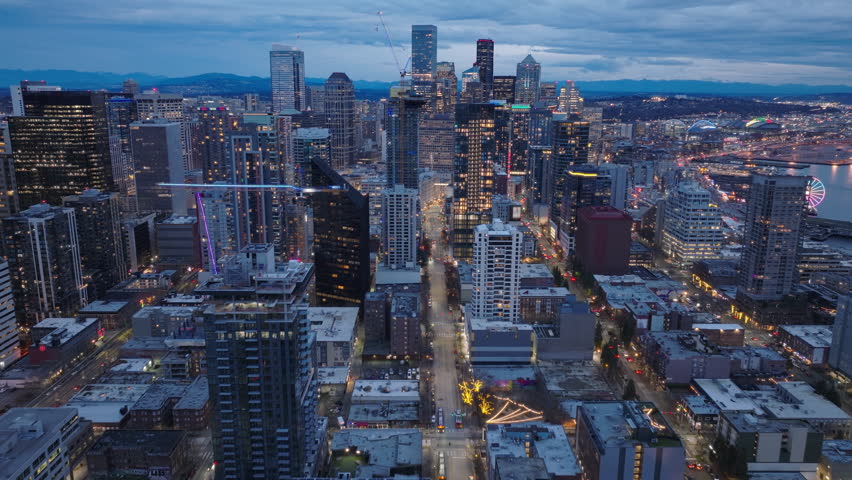 Cityscape at sunset scene. Seattle financial business district at night. Business background at colorful sunset sky. Downtown dusk skyline Washington. Aerial view of sunset skyline Seattle city USA 4K
