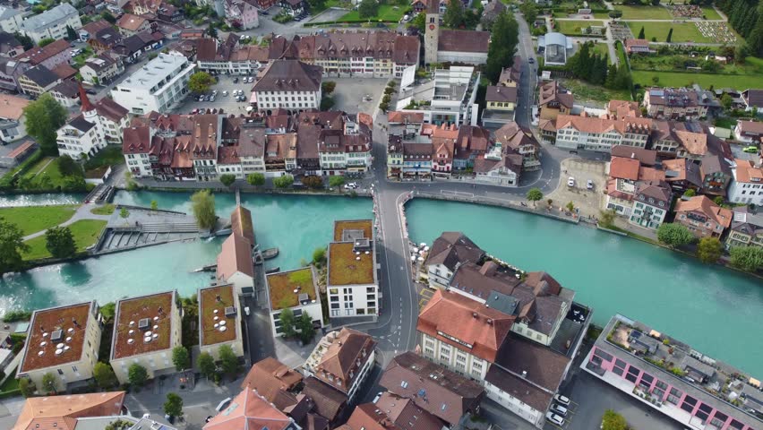 Interlaken, Switzerland: Aerial downward drone footage of the Interlaken old town with the Aar river, the market square (Marktbrunnen) and the Unterseen old church in Canton Bern