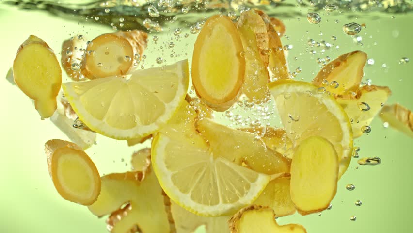 Super Slow Motion Shot of Ginger Slices and Lemon Slices Falling into Water at 1000fps.