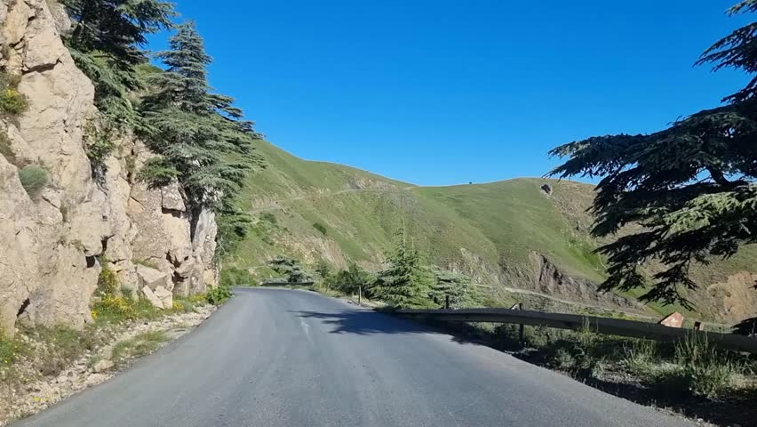 Experience the thrill of adventure as you navigate through the serene beauty of the Algerian mountains, with cascading clouds adding a touch of mystery to the landscape