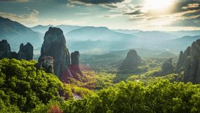 Majestic Meteora: Aerial View of Ancient Monasteries and Sandstone Rock Formations Illuminated by Sunlight in Full 4K Video