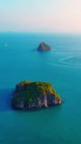 Aerial drone video of tropical paradise exotic island bay. An idyllic, remote island is surrounded by coral reef.  Aerial vertical, vertical video background.