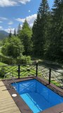 Vertical video of a beautiful blue swimming pool on the private terrace overlooking the mountains