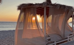 White beach canopies. Luxury beach tents at a resort. Beach holidays concept. Scenic view of waves rushing at sandy beach against sky during sunset. 4K video. Horizontal  - Powered by Shutterstock - Get 15% off with code: PIKWIZARD15