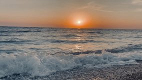 Scenic view of waves rushing at sandy beach against sky during sunset. High quality FullHD footage. 4K video
