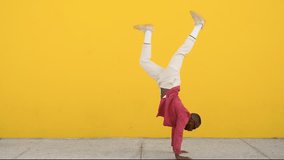 Happy excited cool stylish funky young African Black man dancer wearing sunglasses feeling joy having fun dancing, jumping standing at yellow color urban wall background. Full body. - Powered by Shutterstock - Get 15% off with code: PIKWIZARD15