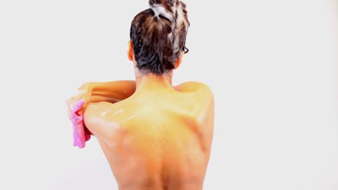 young woman taking shower and washing her hair - back view