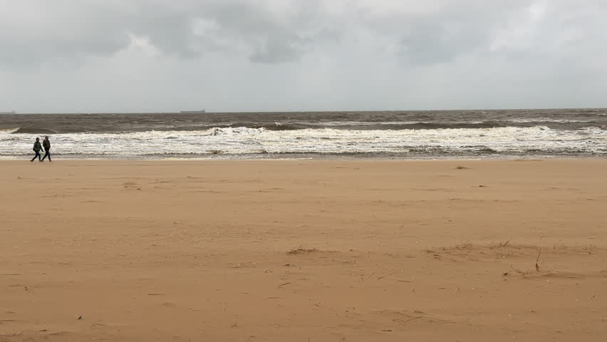 Tourists walk along the shore of a stormy sea Royalty-Free Stock Footage #3484269467