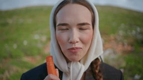 Woman biting fresh carrot healthy vegetable closeup. Happy vegetarian enjoying organic crunchy food on green field. Smiling girl look camera mouth chewing. Mindful eating sustainable lifestyle concept - Powered by Shutterstock - Get 15% off with code: PIKWIZARD15