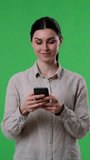 Happy Woman Messaging Using Phone On Green Background