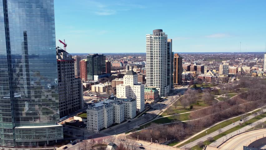 aerial flyby of large apartment buildings along a road and park (Milwaukee, WI)