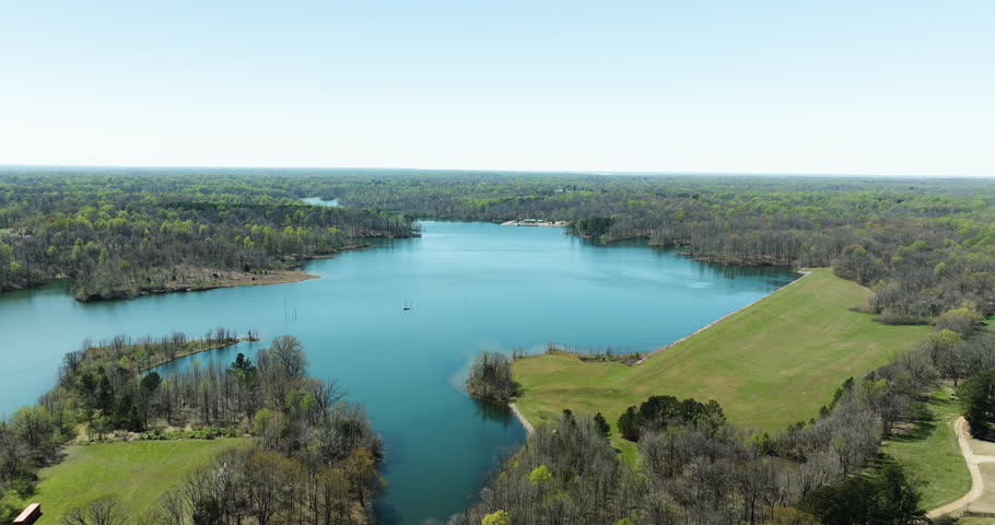 Glen Springs Lake Surrounded By Dense Forest And Green Meadow During Spring In Tennessee, USA. - aerial shot