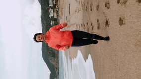 Jogging young female during outdoor cardio training at seashore. Active woman running on beach near sea enjoying fresh air. Fitness and sport concept. Vertical video
