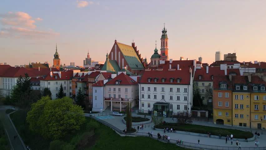 warsaw city old town aerial view drone at sunset rising up revealing castle square and modern business district with high-rise building in the background