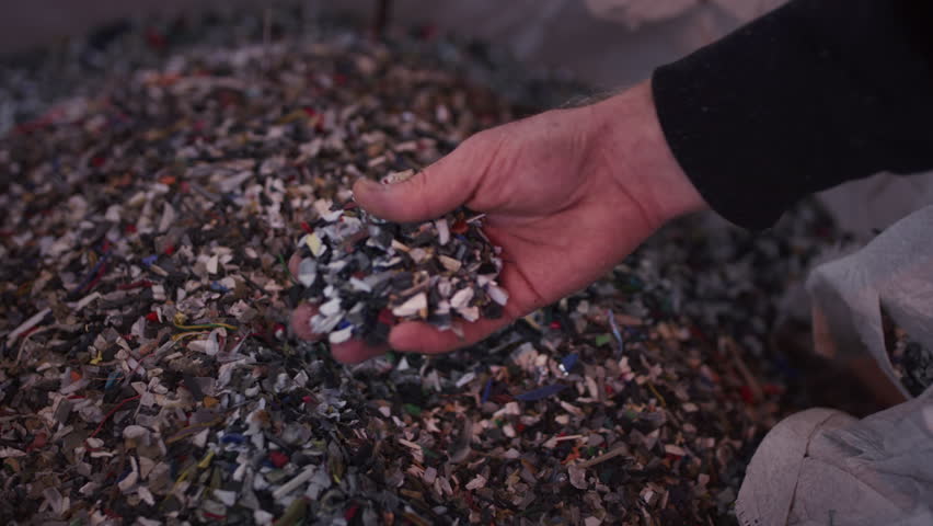 Man worker shows pieces of recycled trash in hand as tangible testament to plant mission slow motion. Worker displays recycled materials as symbol of efforts to maximize resource utilization Royalty-Free Stock Footage #3484522011