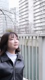 Vertical slow-motion video of a Japanese woman in her 20s walking around Gotanda Station, Shinagawa-ku, Tokyo in winter